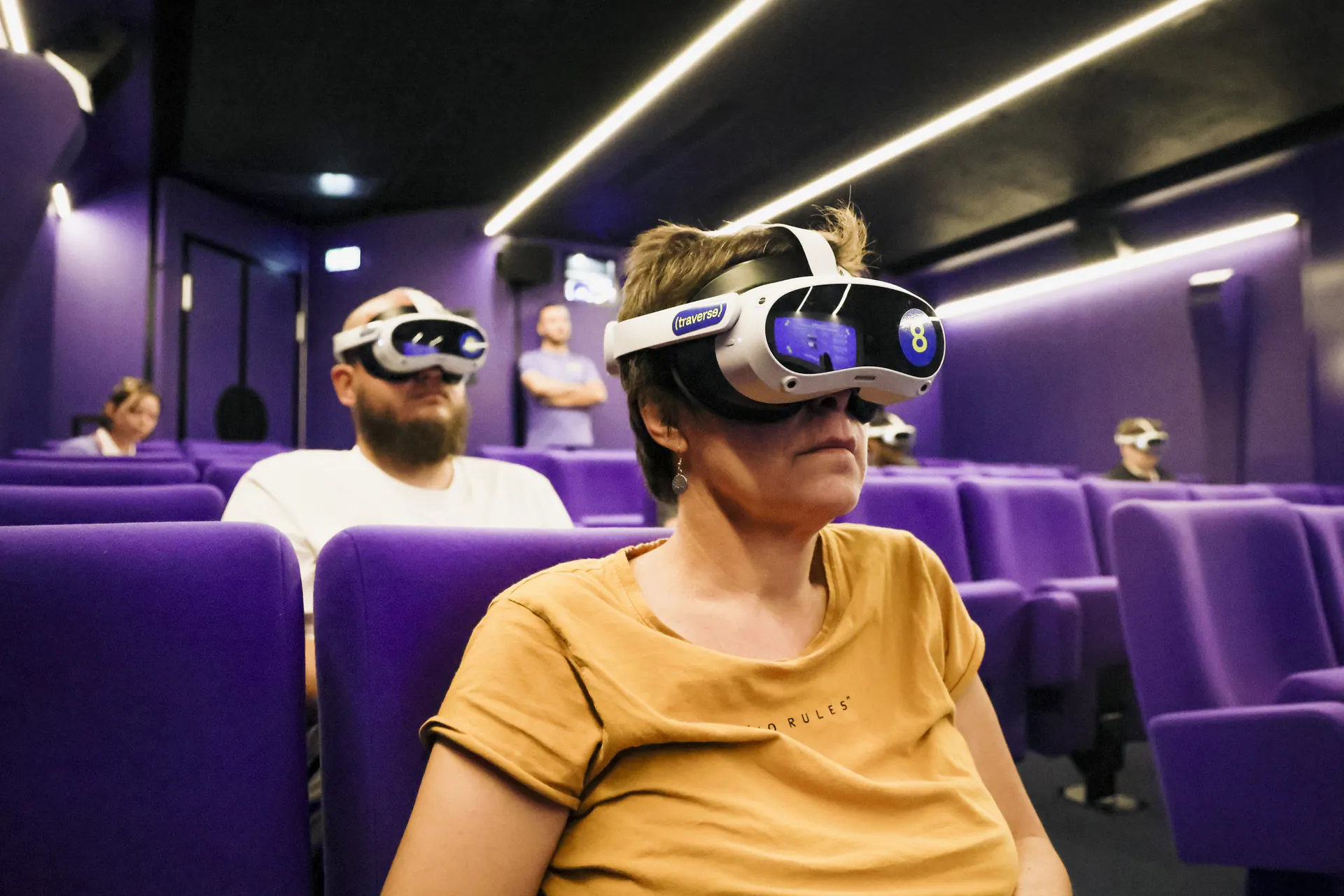 Spectatrice équipée d'un casque de réalité virtuelle dans une salle de cinéma