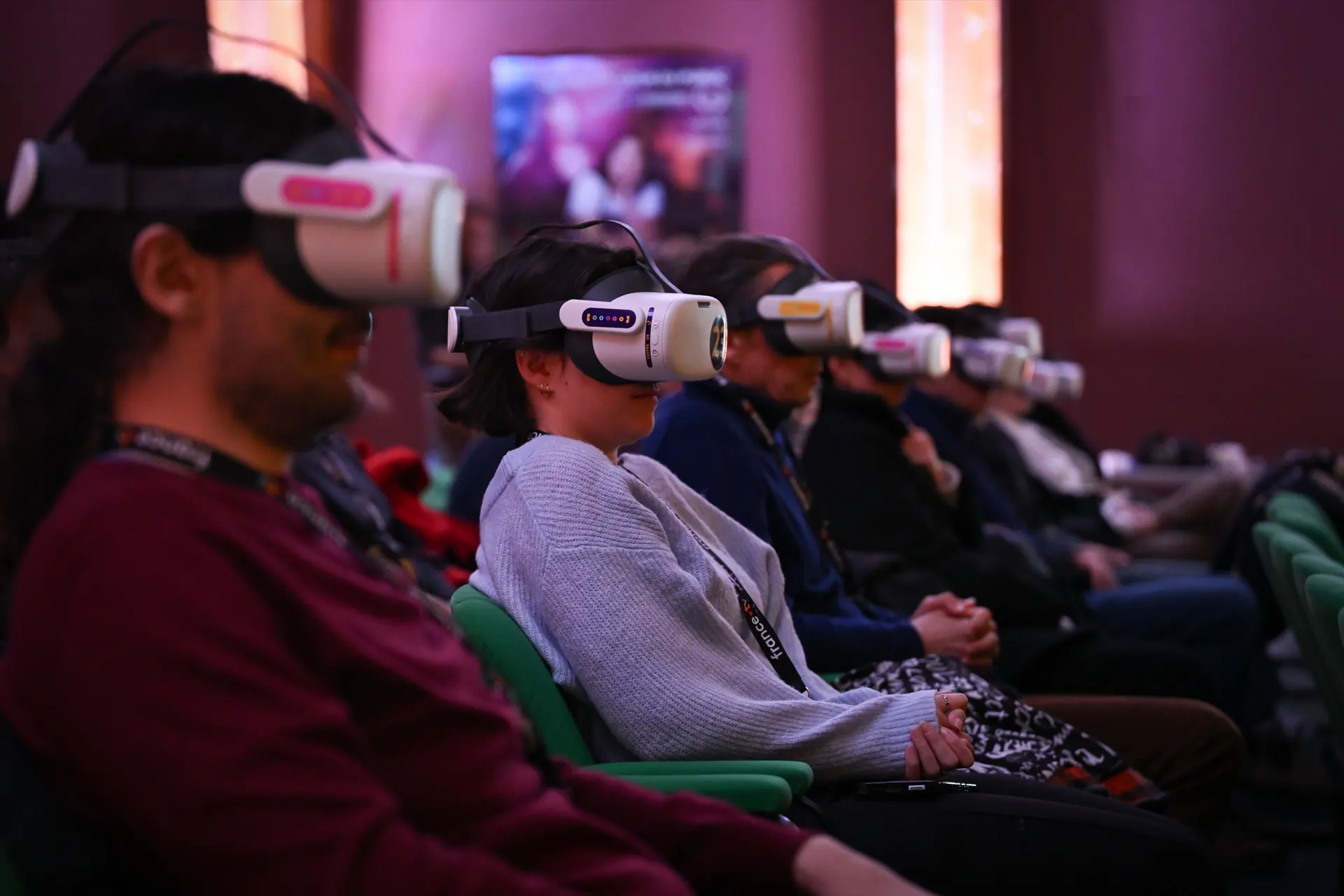 Public équipé de casques de réalité virtuelle devant un écran