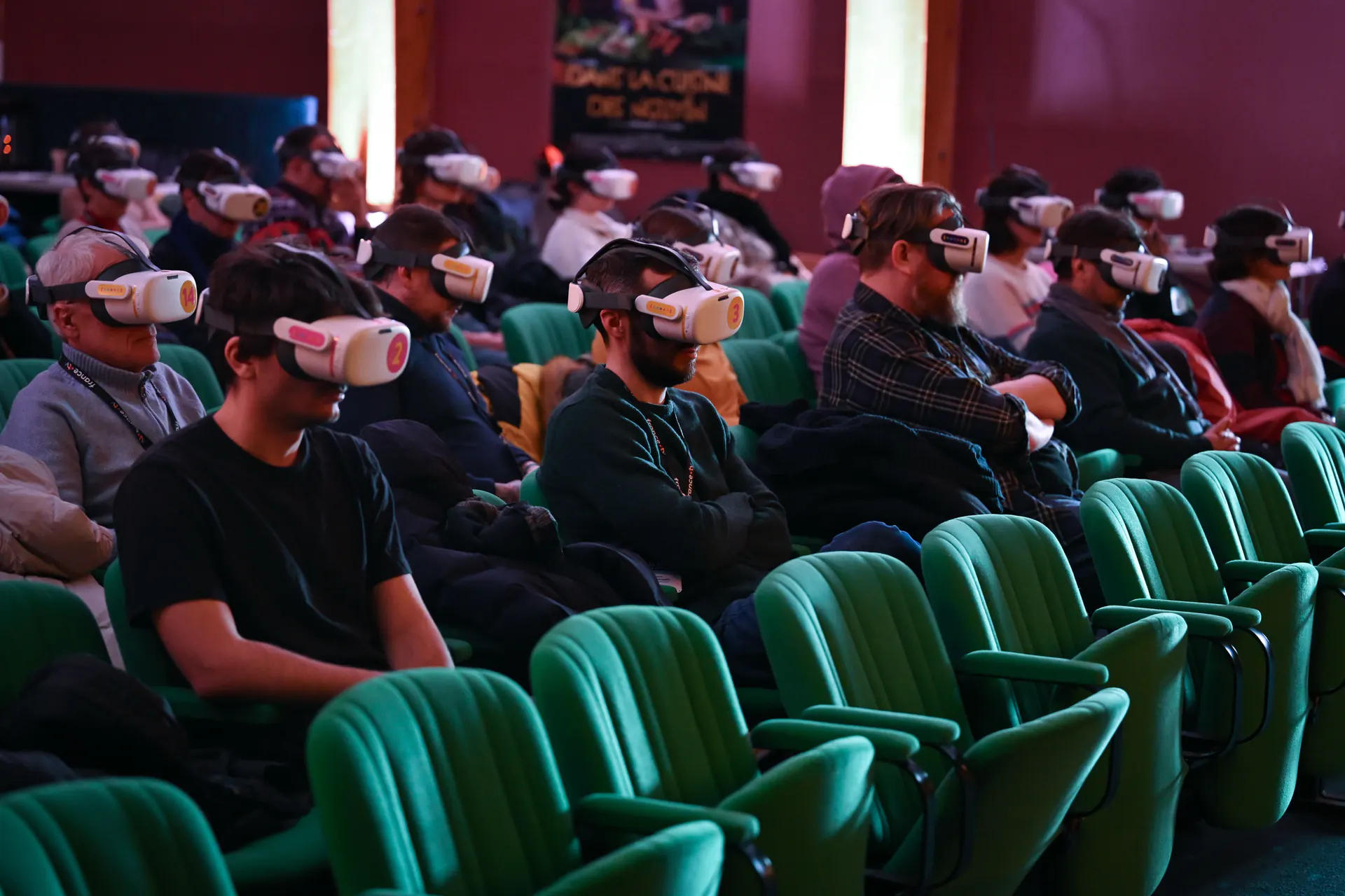 Salle de cinéma comble, spectateurs équipés de casques de réalité virtuelle