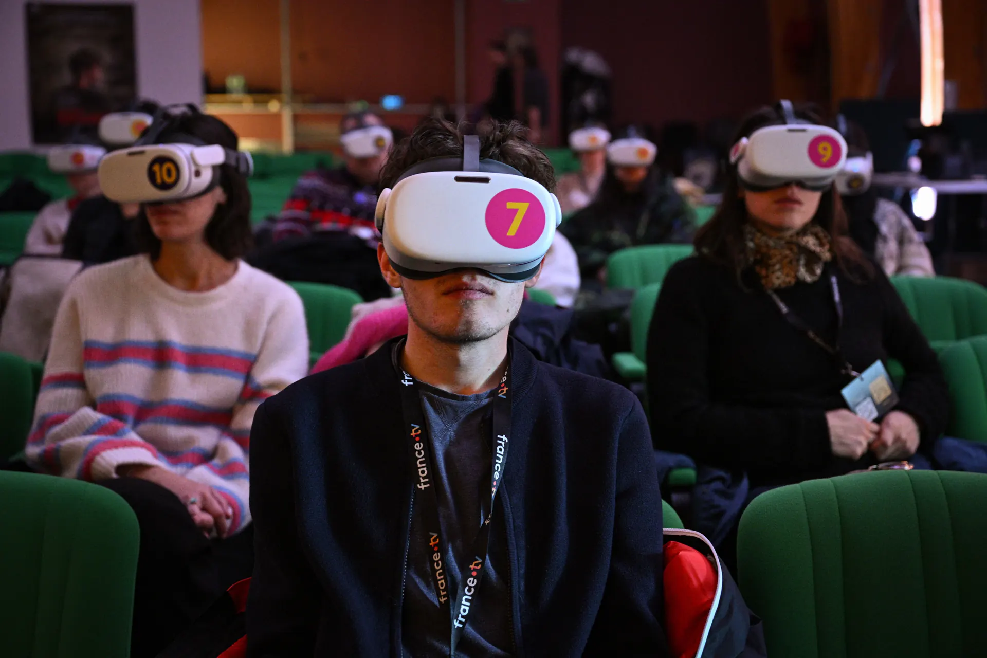 Spectateurs équipés de casques de réalité virtuelle dans une salle de cinéma