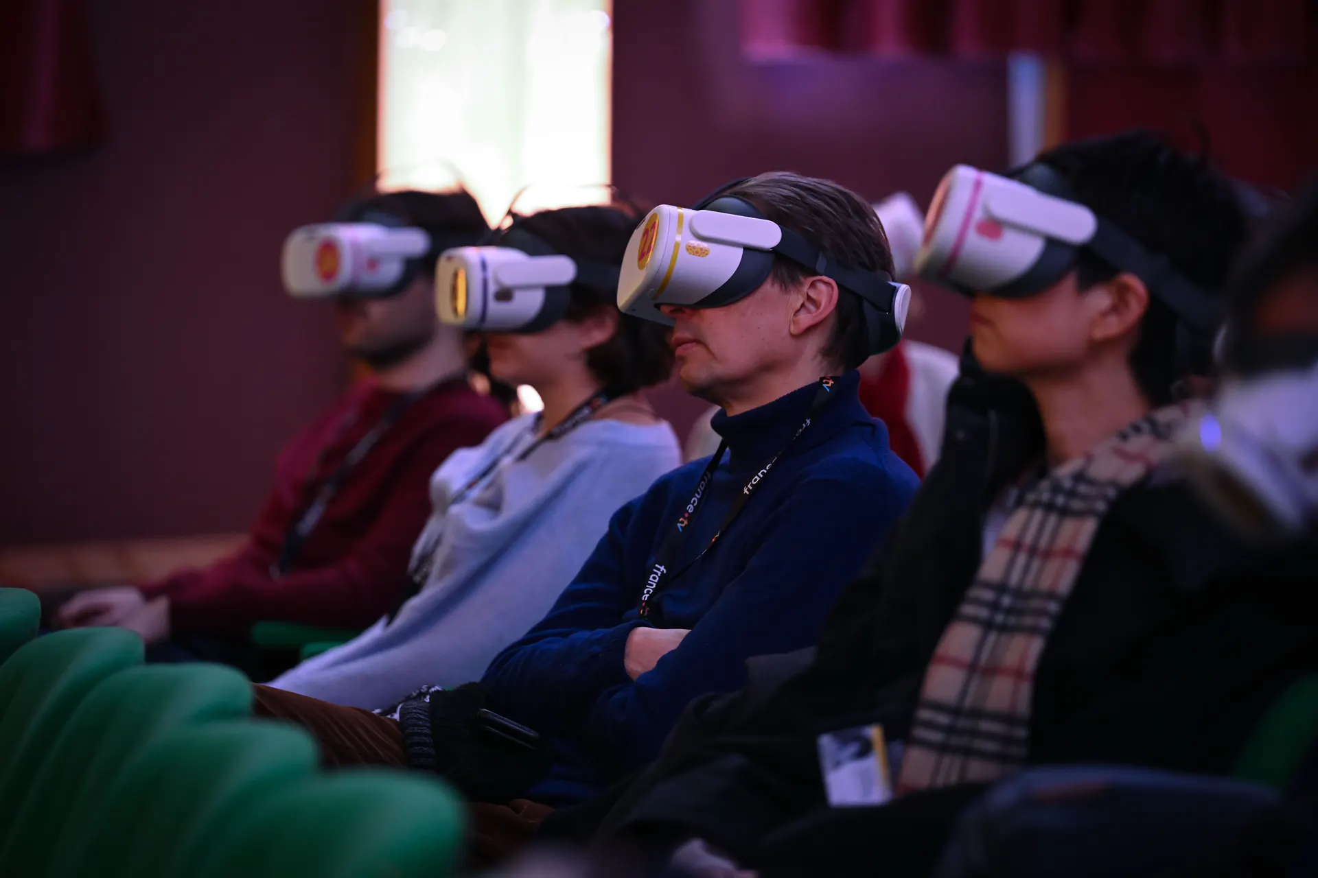 Spectateurs de profil équipés de casques de réalité virtuelle