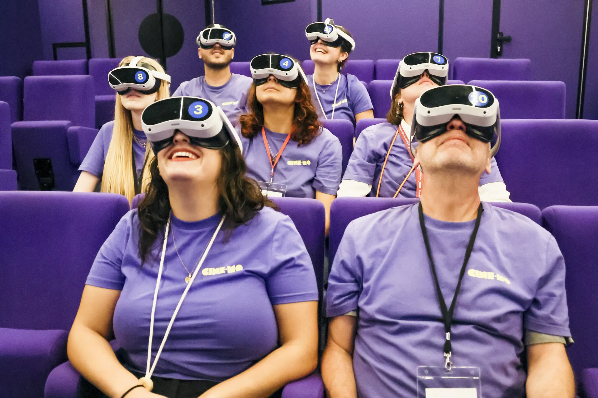 Rangées de spectateurs équipés de casques de réalité virtuelle, le regard levé